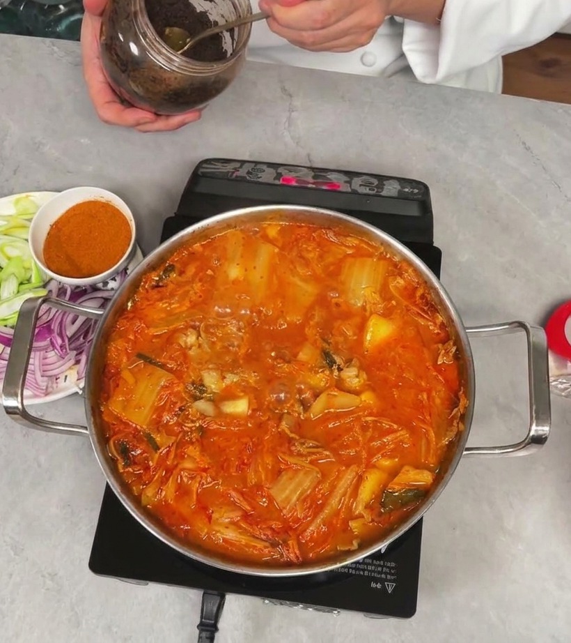 김치찌개에 진한 된장을 반 숟가락 넣는 모습