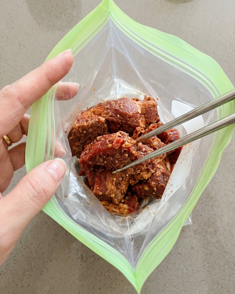 양념된 고기를 지퍼백에 담고 공기를 빼서 밀봉하는 과정