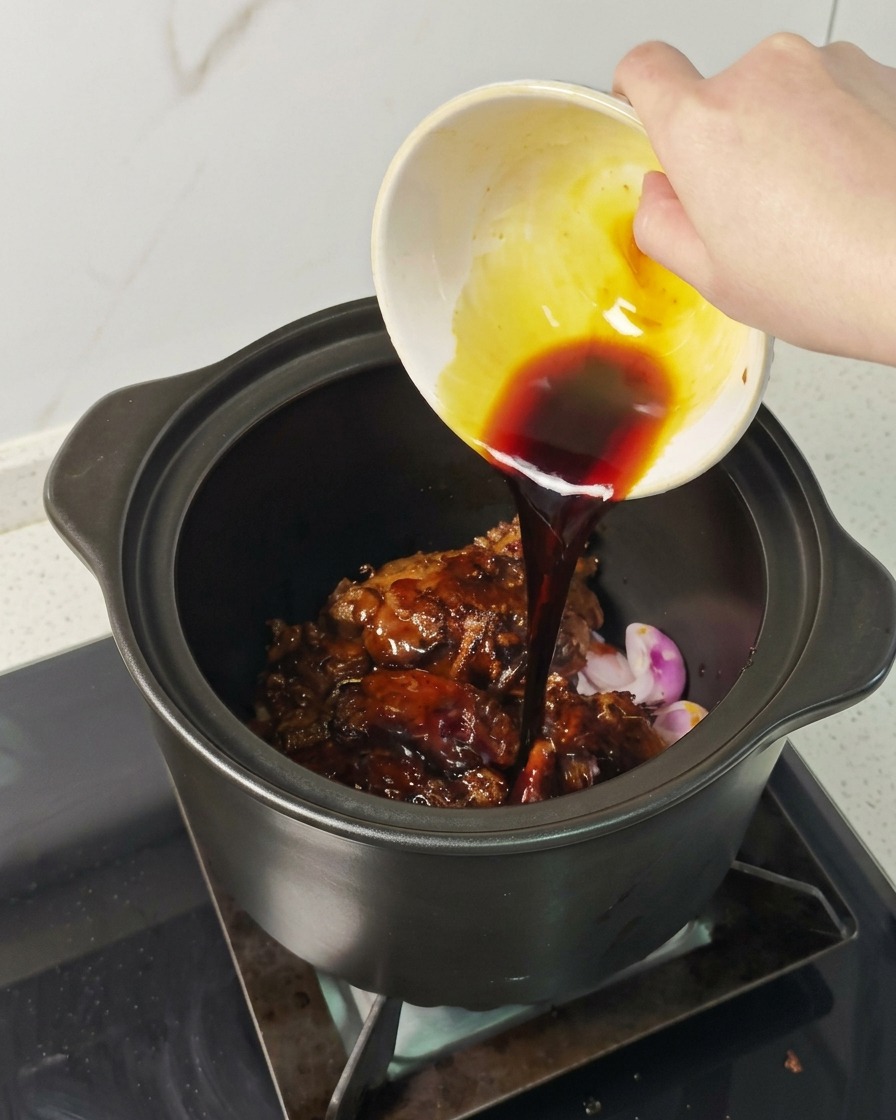 고기 위로 진한 갈색 소스를 골고루 부어주는 손