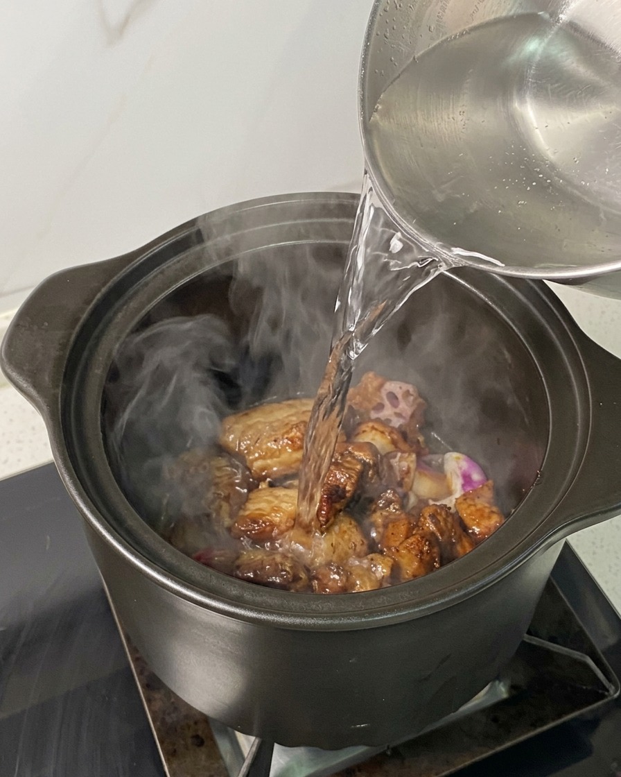 냄비 속 재료들이 잠기도록 뜨거운 물을 붓는 모습