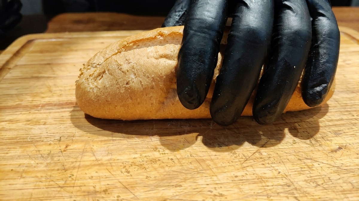 도마 위에 반으로 가른 통밀 바게트를 놓는 모습