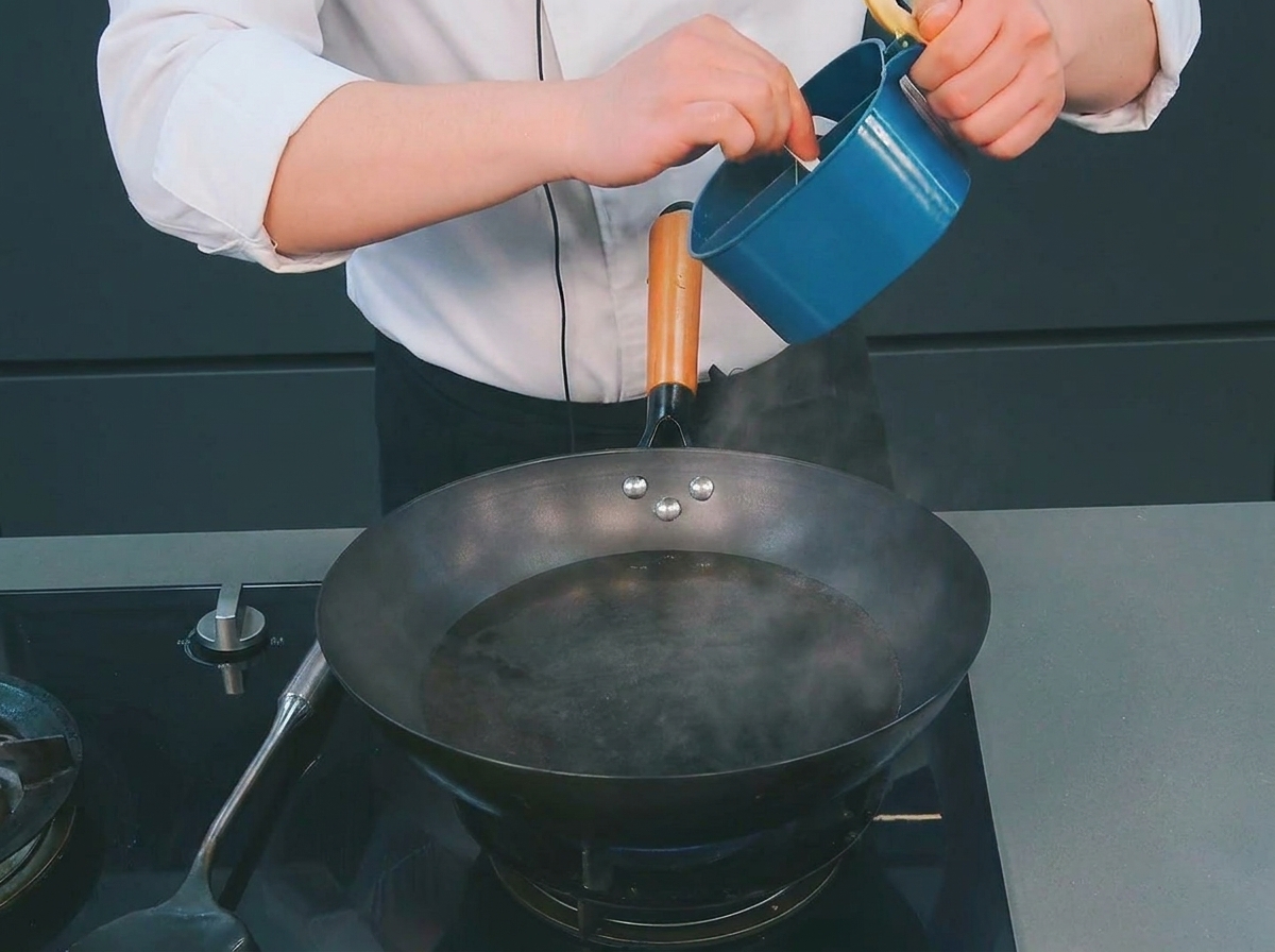 끓는 물이 담긴 웍에 소금을 넣는 모습