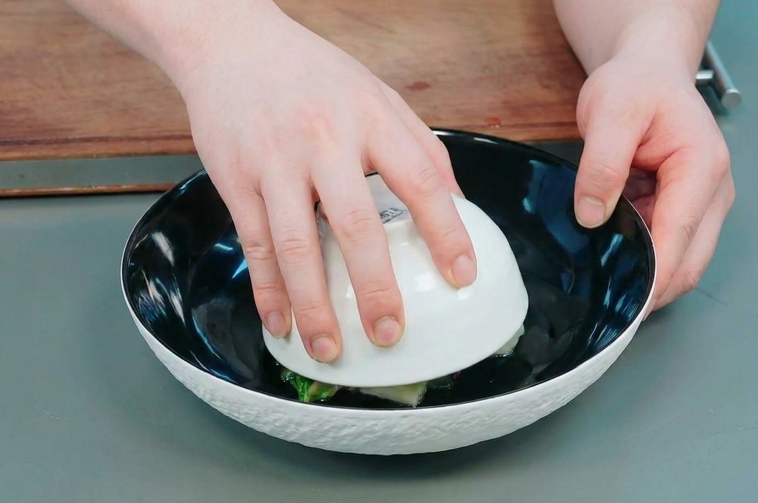 작은 볼을 뒤집어 서빙 접시에 오크라 돔을 올리는 모습