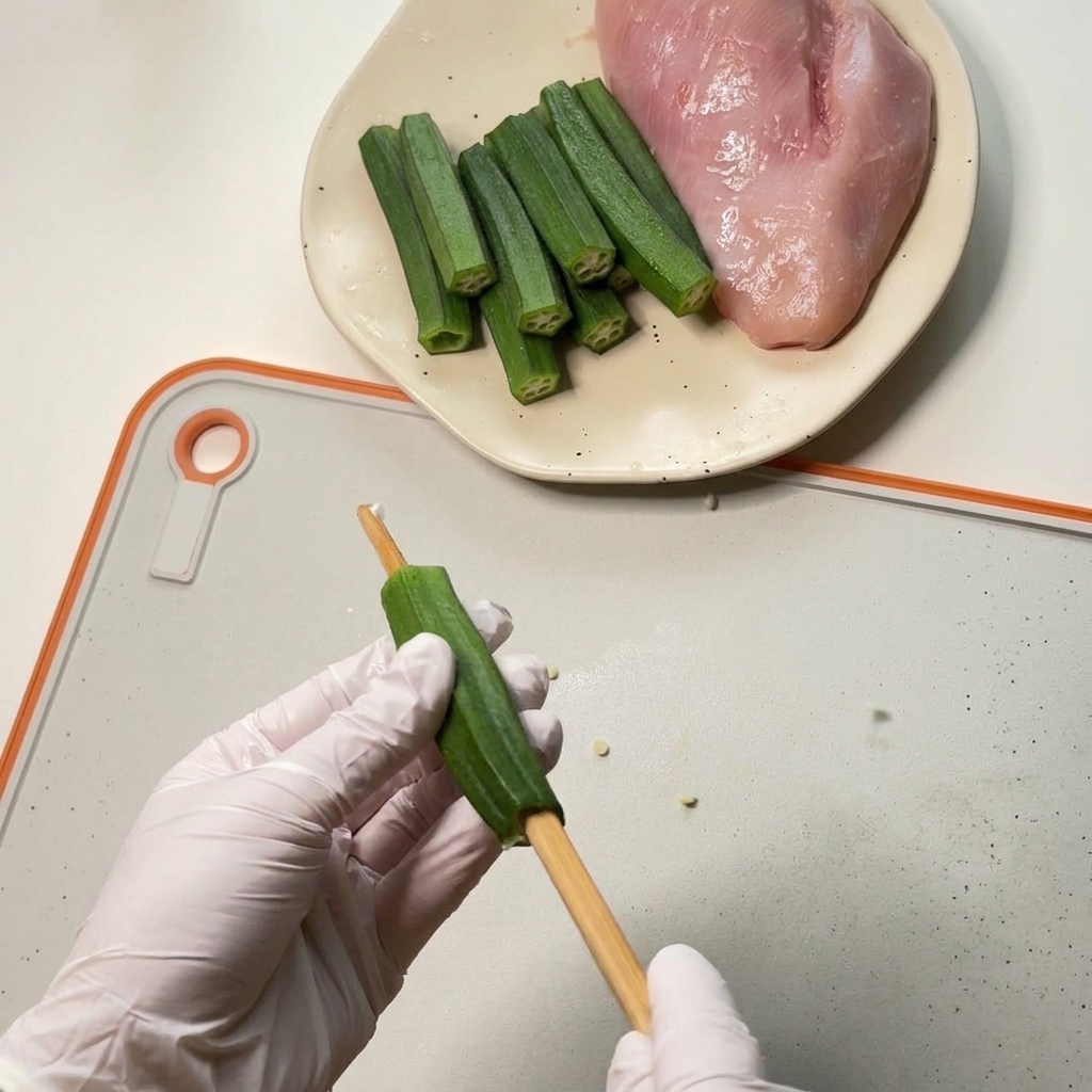 도마 위에서 나무 젓가락을 이용해 그린 오크라 중앙의 씨를 밀어내어 속을 비우는 모습.