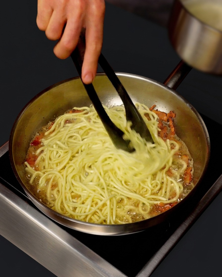 팬에 담긴 면과 관찰레 위로 면수를 붓고 섞는 모습.