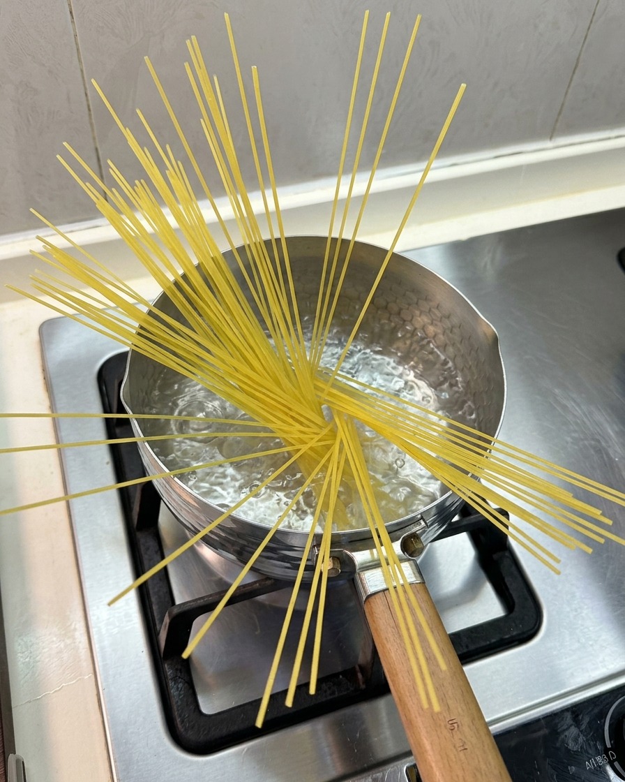 냄비에 끓는 물과 펼쳐진 스파게티 면