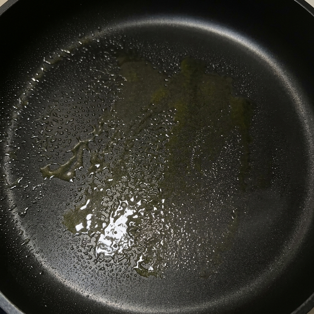 버터와 올리브 오일이 녹아 코팅된 검은색 프라이팬.