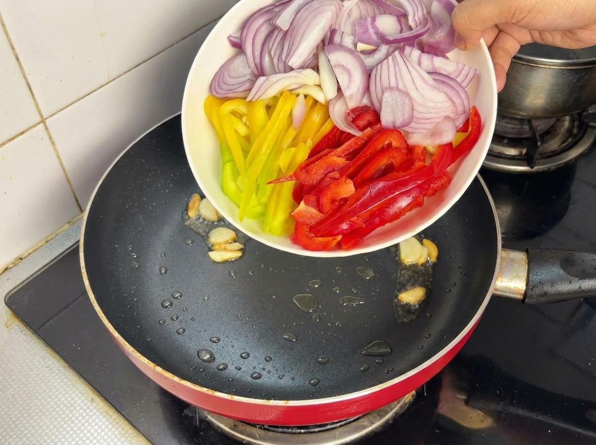 팬에 양파와 파프리카를 넣고 센 불에서 볶는 모습.