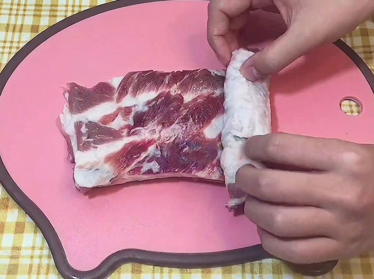 도마 위에서 칼집을 낸 삼겹살을 돌돌 마는 모습.
