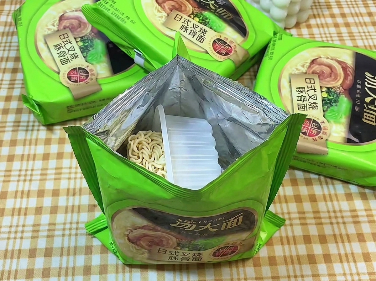 라멘 봉지를 뜯어 내용물을 확인하는 모습.