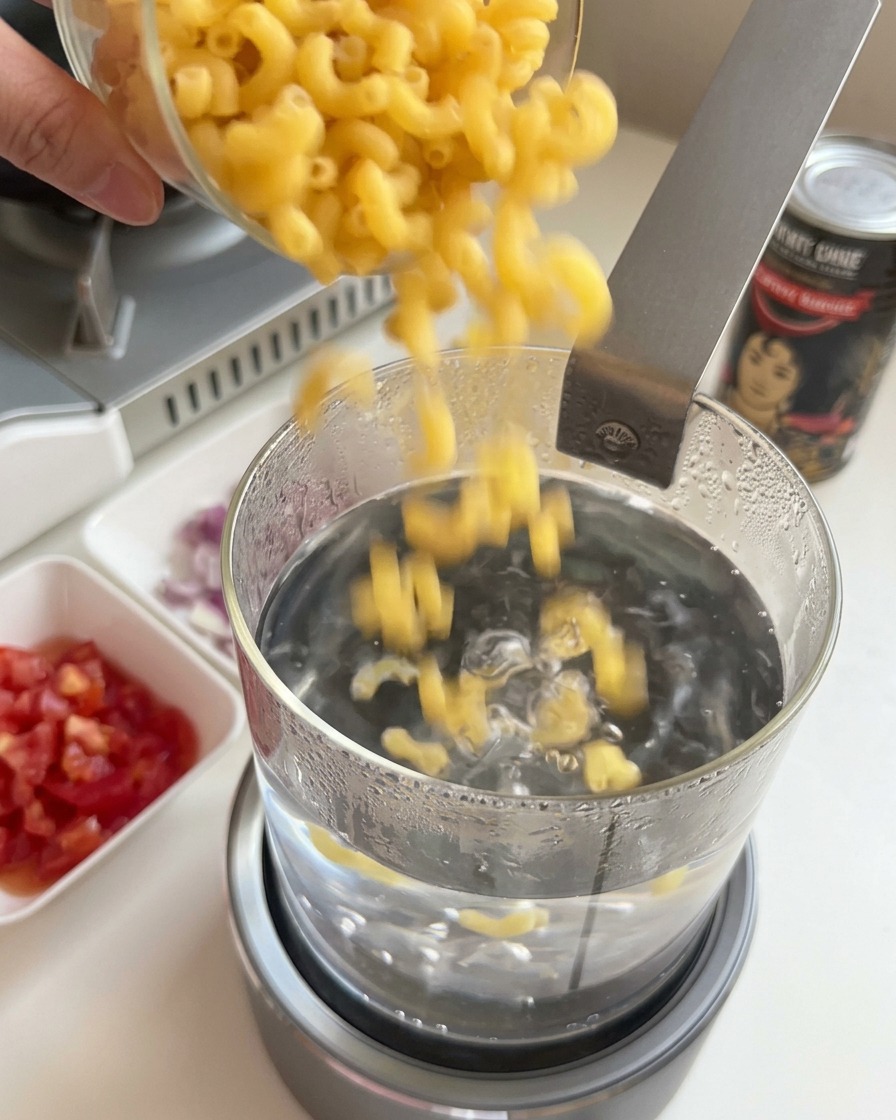 끓는 물이 담긴 냄비에 건 마카로니를 넣는 모습
