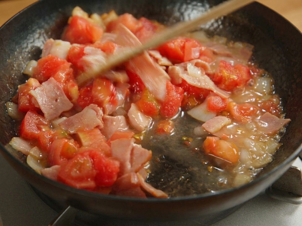 토마토가 으깨지며 베이컨, 양파와 함께 걸쭉하게 익어가는 과정.