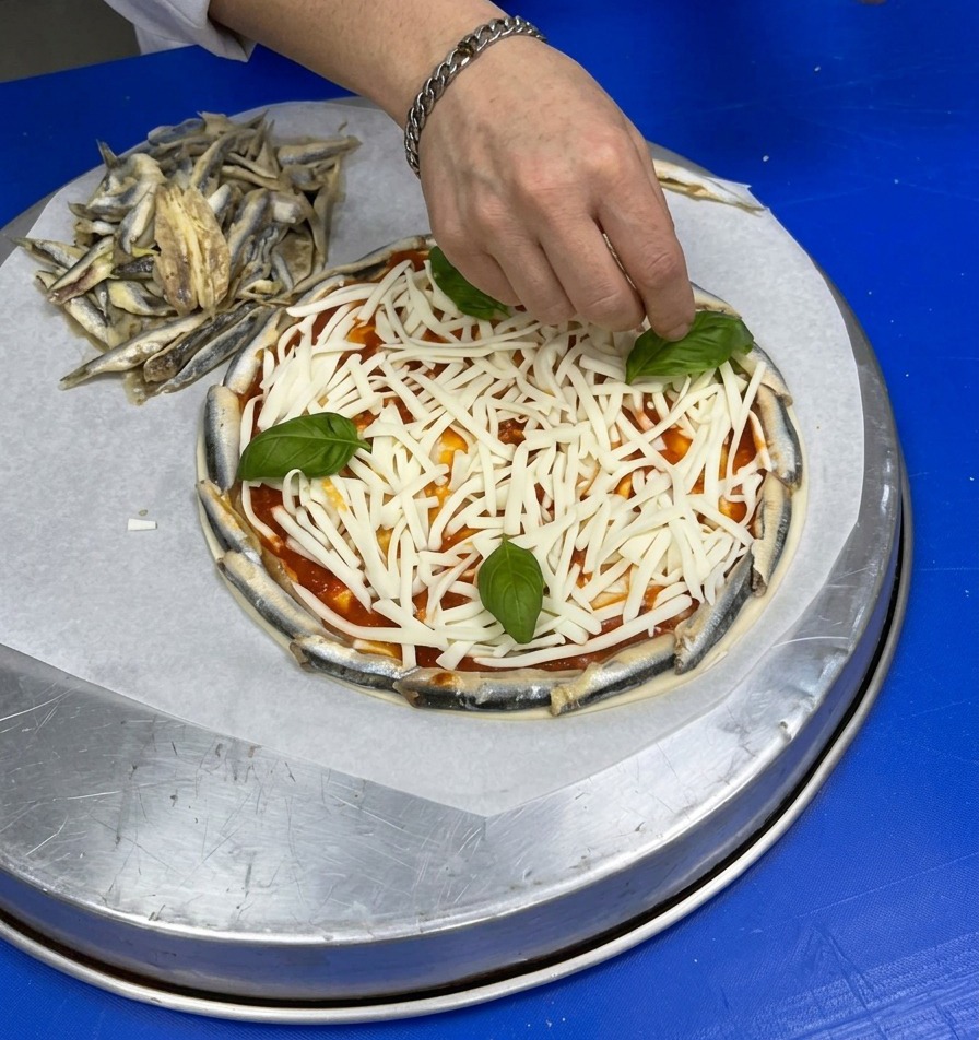 잘게 갈린 치즈 위에 신선한 통바질 잎을 하나씩 올리고 있는 손