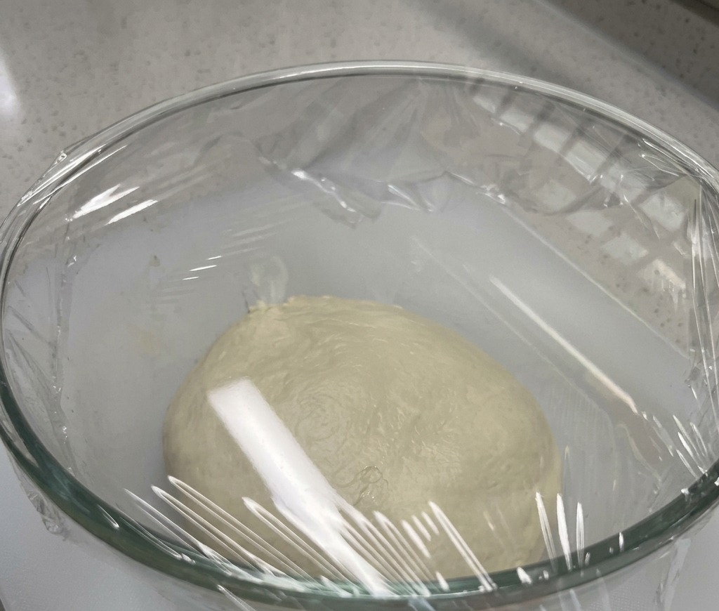 유리 볼에 담긴 반죽이 랩으로 밀봉된 모습