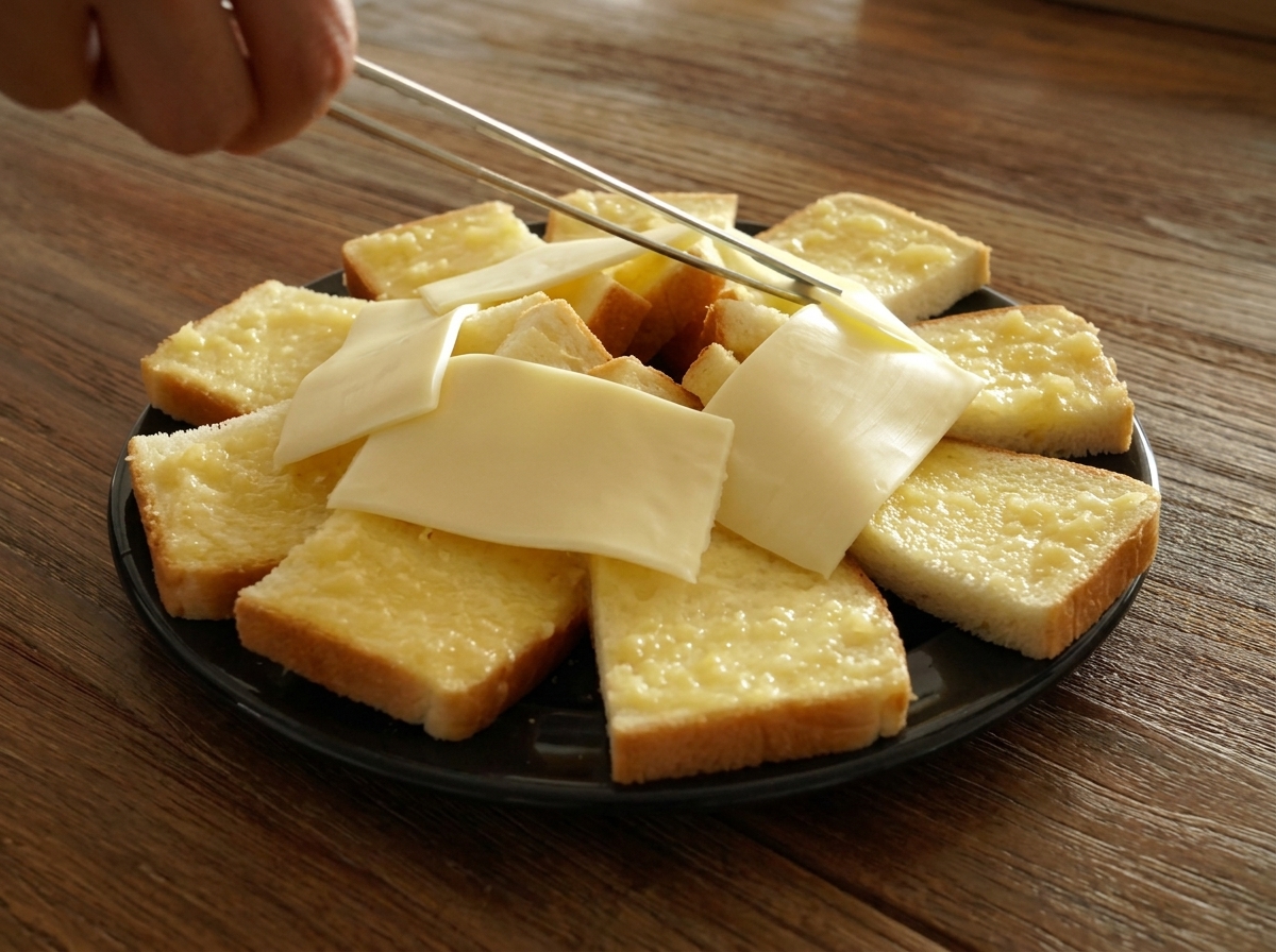 식빵 테두리 안쪽 빈 공간에 슬라이스 치즈를 채워 넣는 모습.