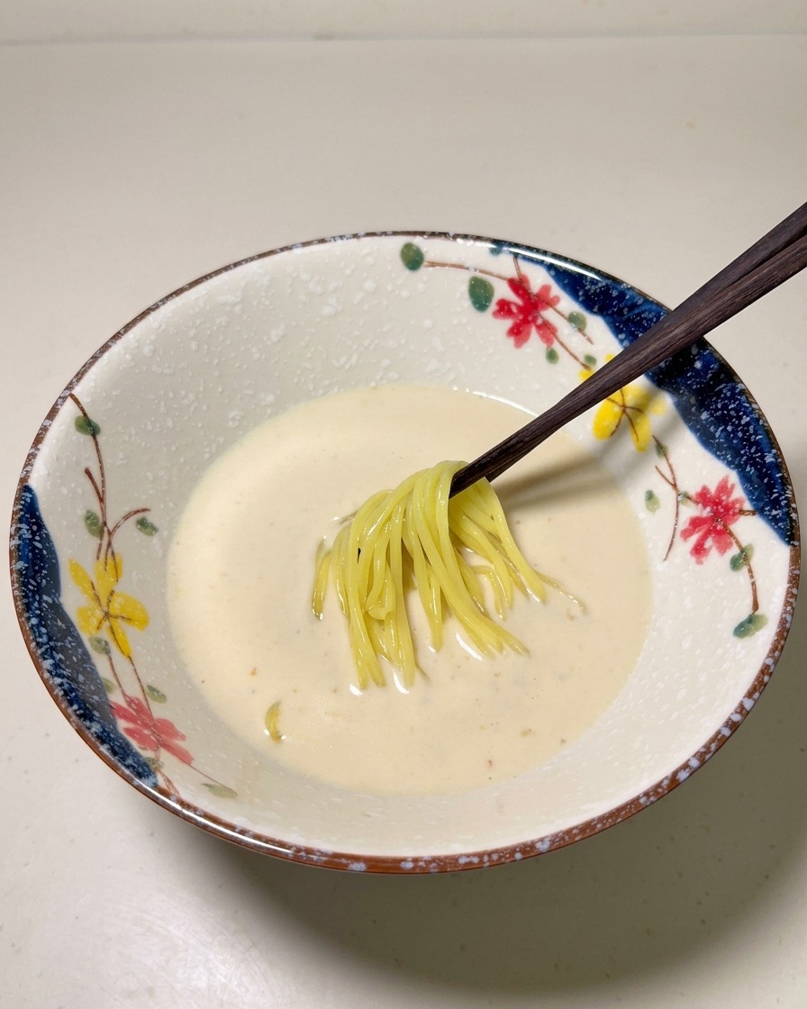 삶아진 노란 라멘 면을 그릇의 육수 속에 담는 모습.