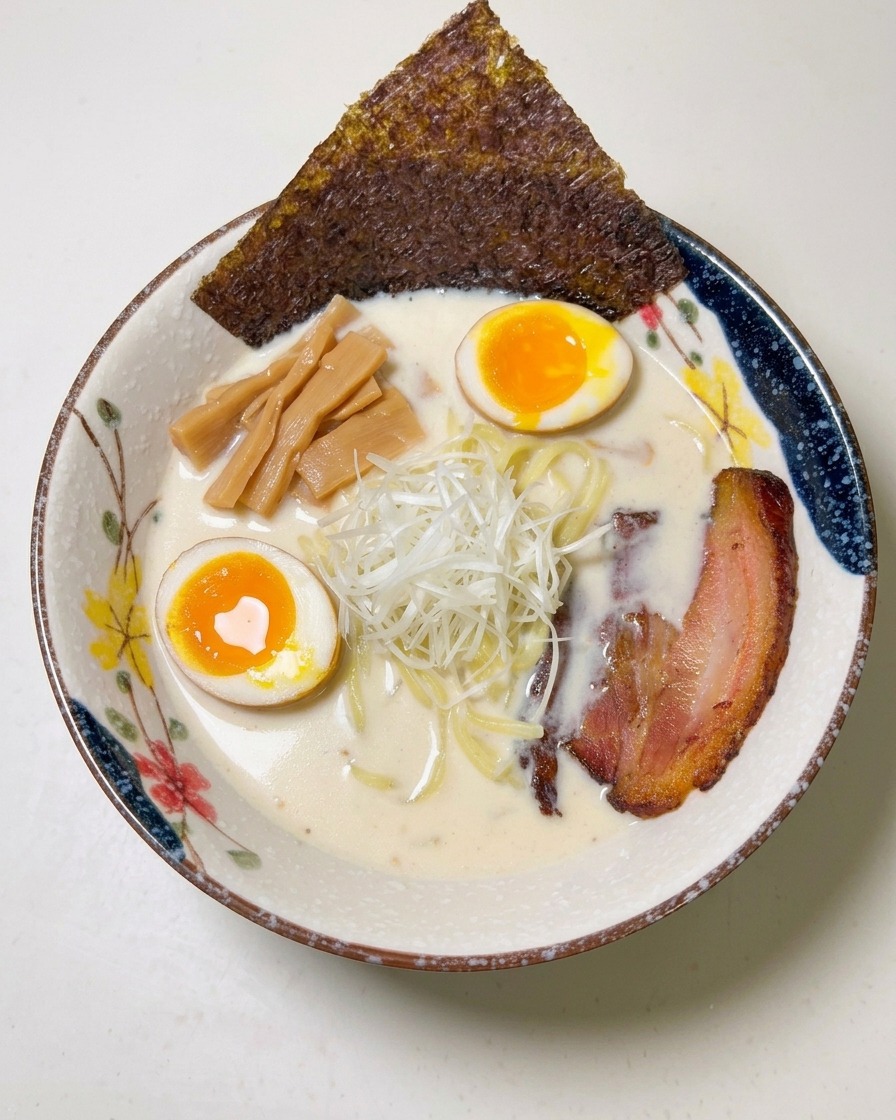 바삭한 김 한 장을 라멘 그릇 가장자리에 꽂는 모습.