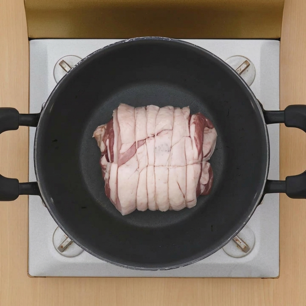 뜨거운 냄비 중앙에서 겉면이 노릇하게 익어가는 차슈 고기 덩어리.