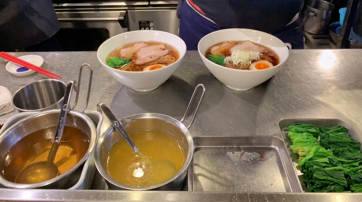 김이 나는 라멘 중앙에 잘게 썬 대파를 한 줌 올리는 모습.