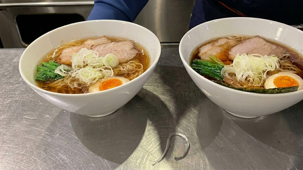 라멘 그릇 가장자리에 바삭한 김 한 장을 꽂아 마무리하는 모습.