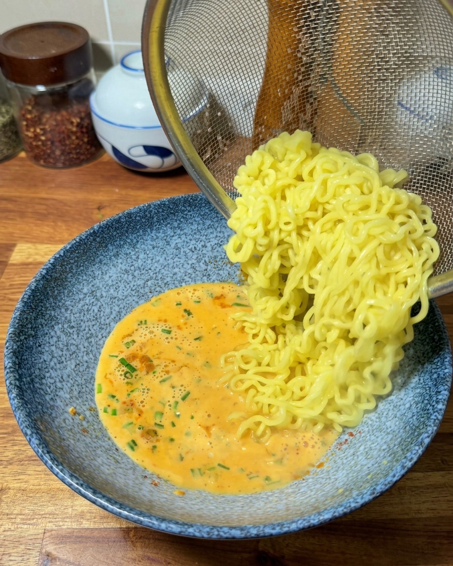 채반을 이용해 물기를 뺀 면을 만들어 둔 국물에 넣는 모습.
