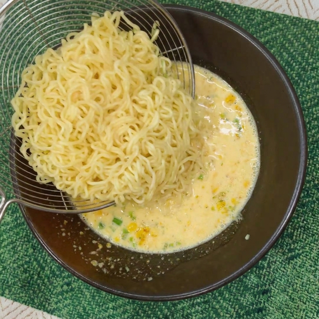 채망으로 삶은 라면 면발을 완성된 국물에 옮겨 담는 모습