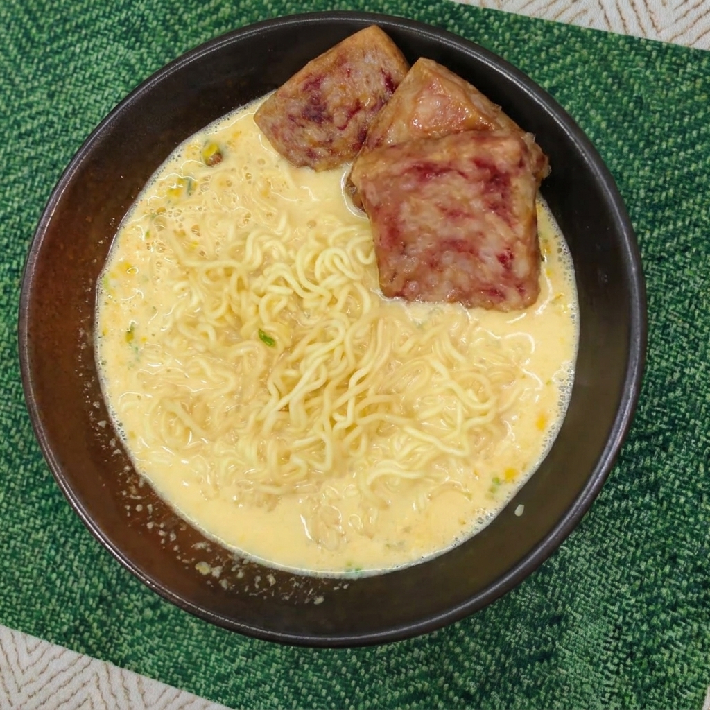 크리미한 라면 위에 노릇하게 잘 구워진 스팸 세 조각이 올라간 모습