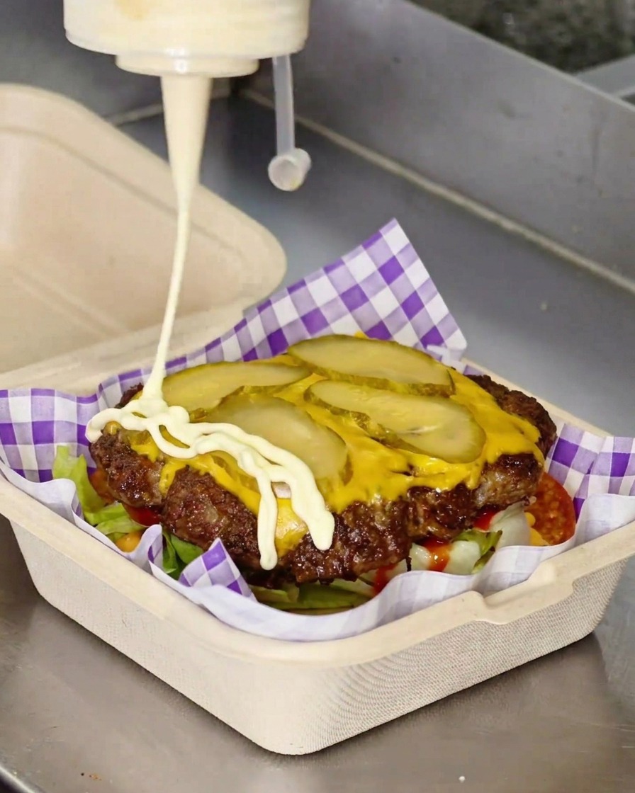 치즈 패티 위에 마요네즈를 지그재그 모양으로 뿌리는 모습.