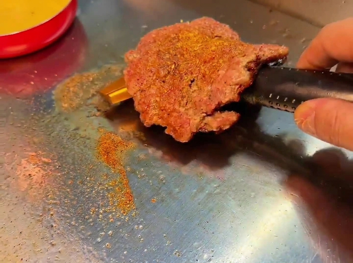 바삭하고 진한 갈색으로 구워진 패티를 뒤집은 모습.