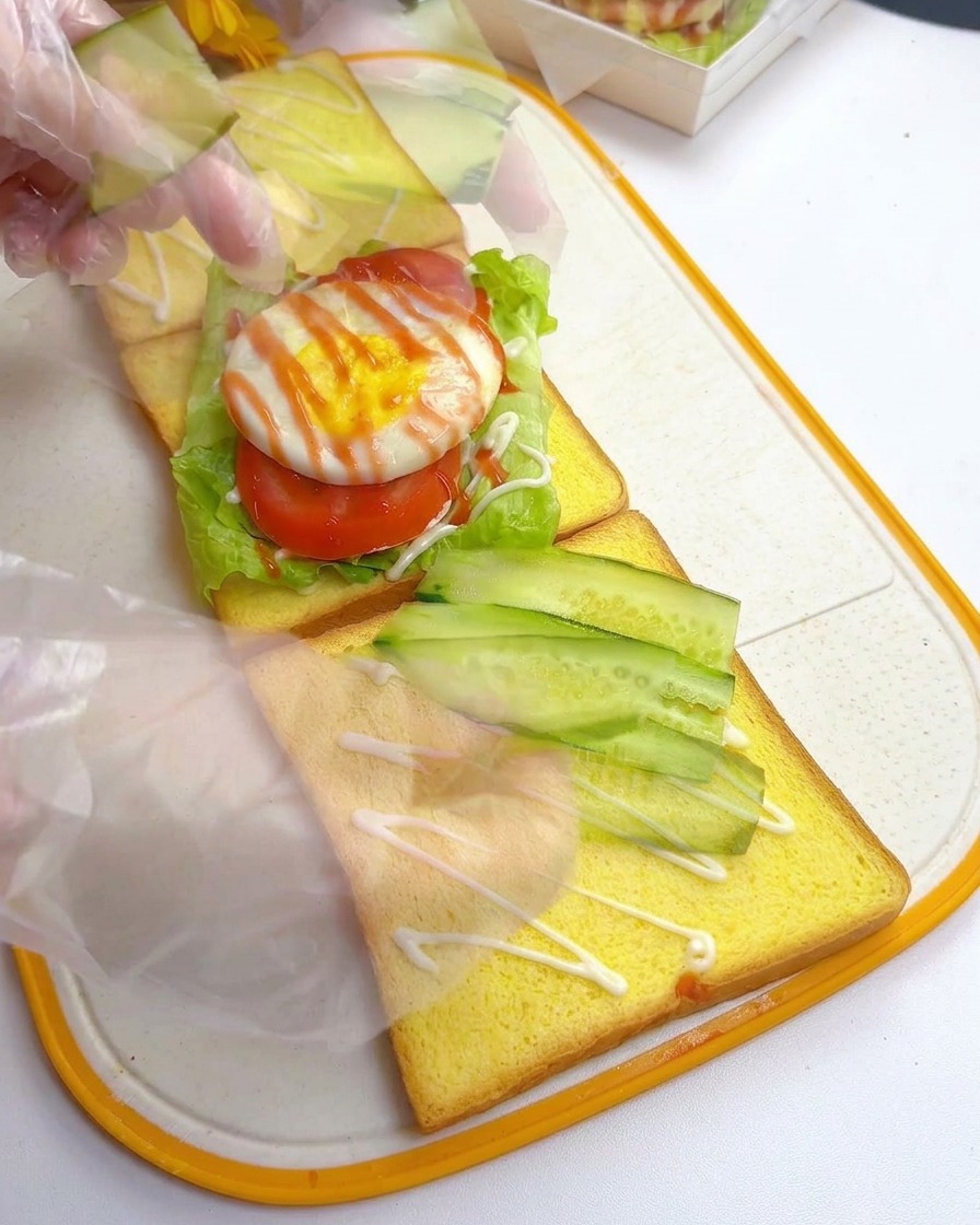 두 번째 식빵 위에 어긋썰기 한 오이를 겹쳐서 배열하는 모습.
