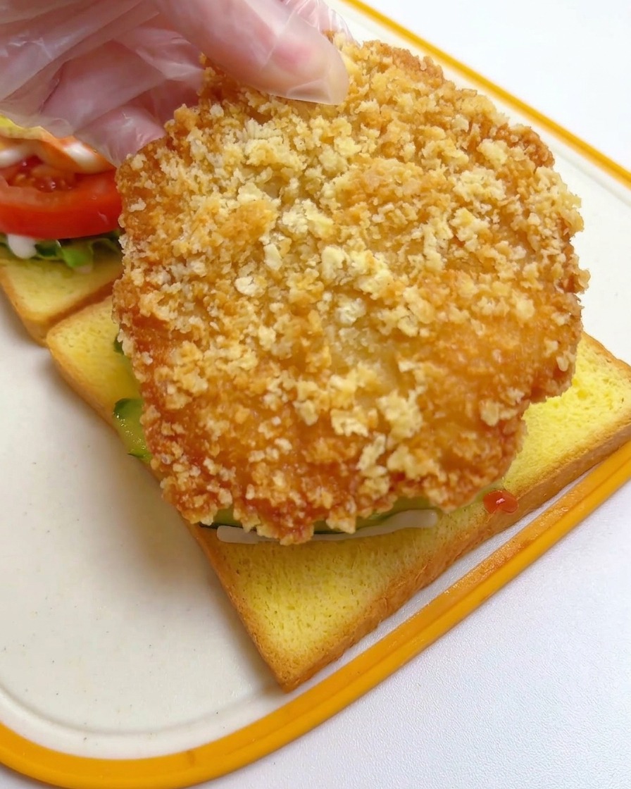 오이 위에 바삭한 치킨 커틀릿을 통째로 올리는 모습.