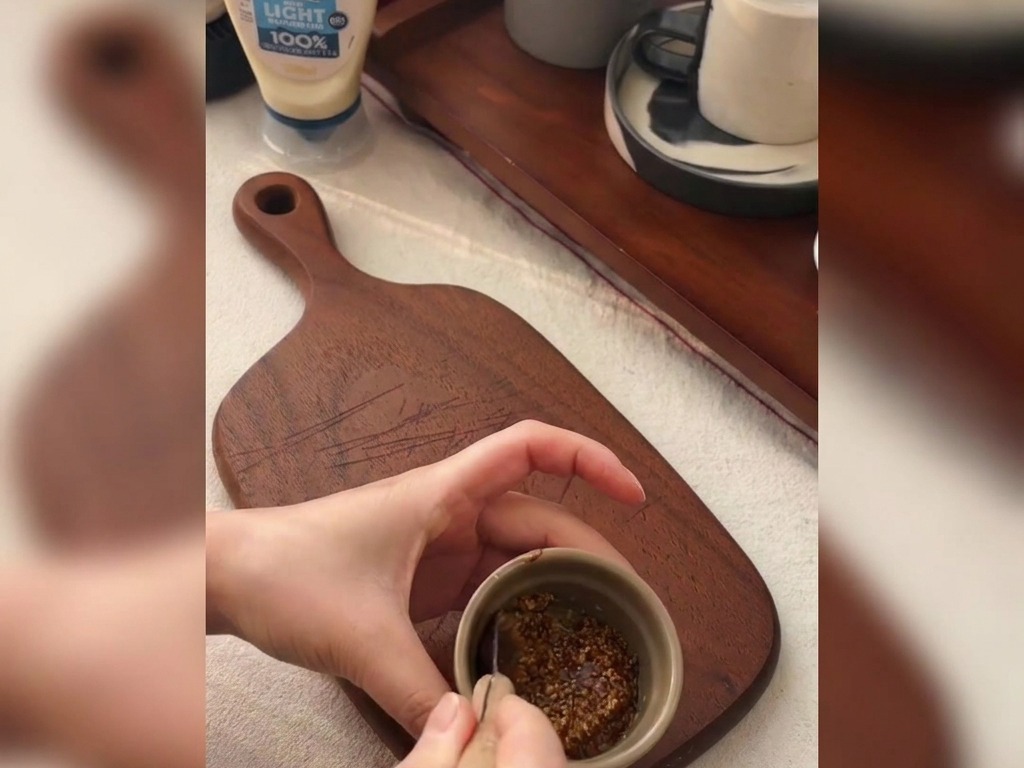 작은 그릇에 홀그레인 머스타드와 꿀을 섞고 있는 손길.