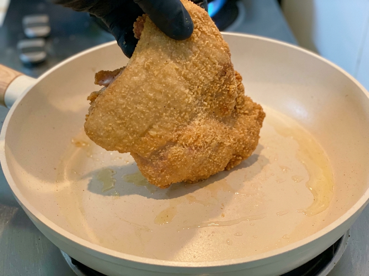 전분 가루를 입힌 닭고기를 팬에 넣고 노릇하게 굽는 모습.