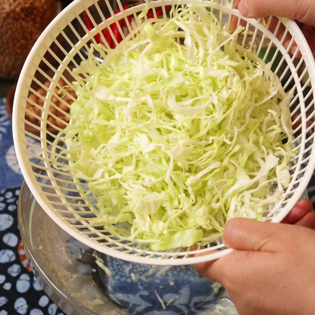 야채 탈수기 바구니에 담겨 물기가 제거된 양배추 채