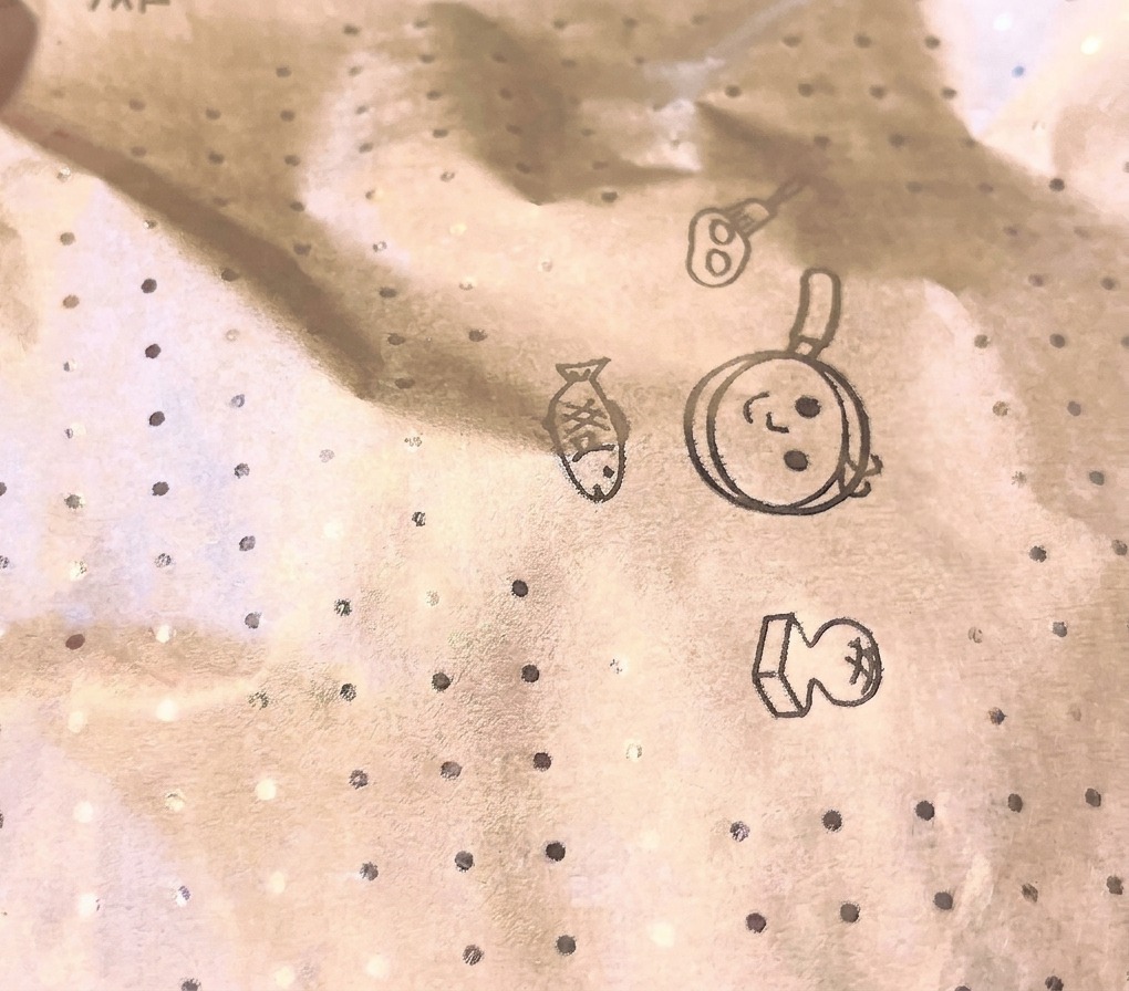 요리 일러스트가 그려진 원형 요리용 종이 뚜껑(오토시부타)이 덮인 팬에서 재료가 끓고 있는 모습