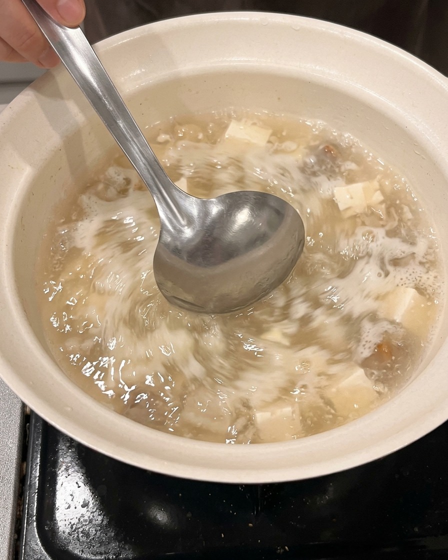 계량컵에서 깨끗한 냄비로 물과 사케를 붓는 모습.