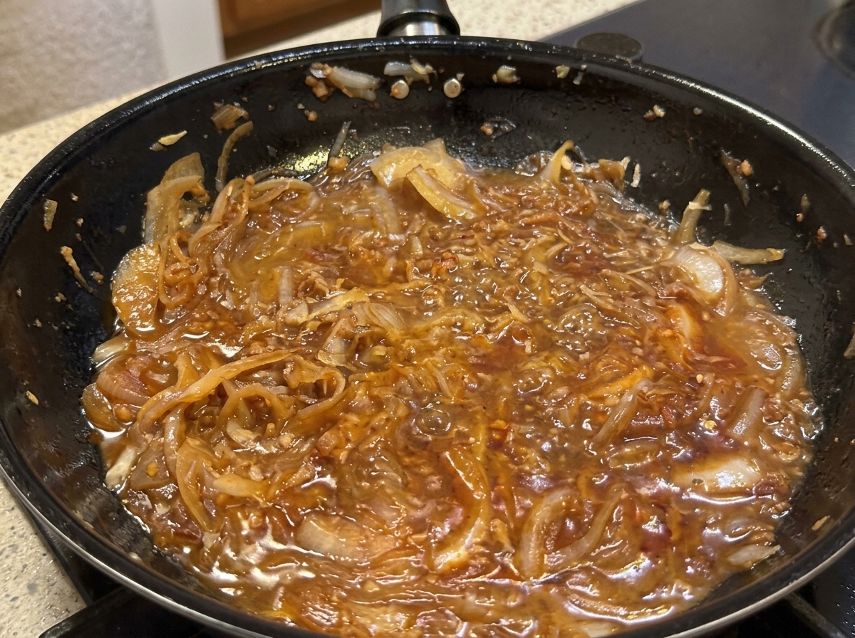 팬에 파마산 치즈를 갈아 넣고 생크림을 부어 소스를 만드는 모습.
