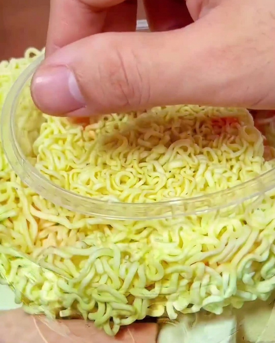 라면 위에 잘게 썬 김치를 듬뿍 올리는 모습.