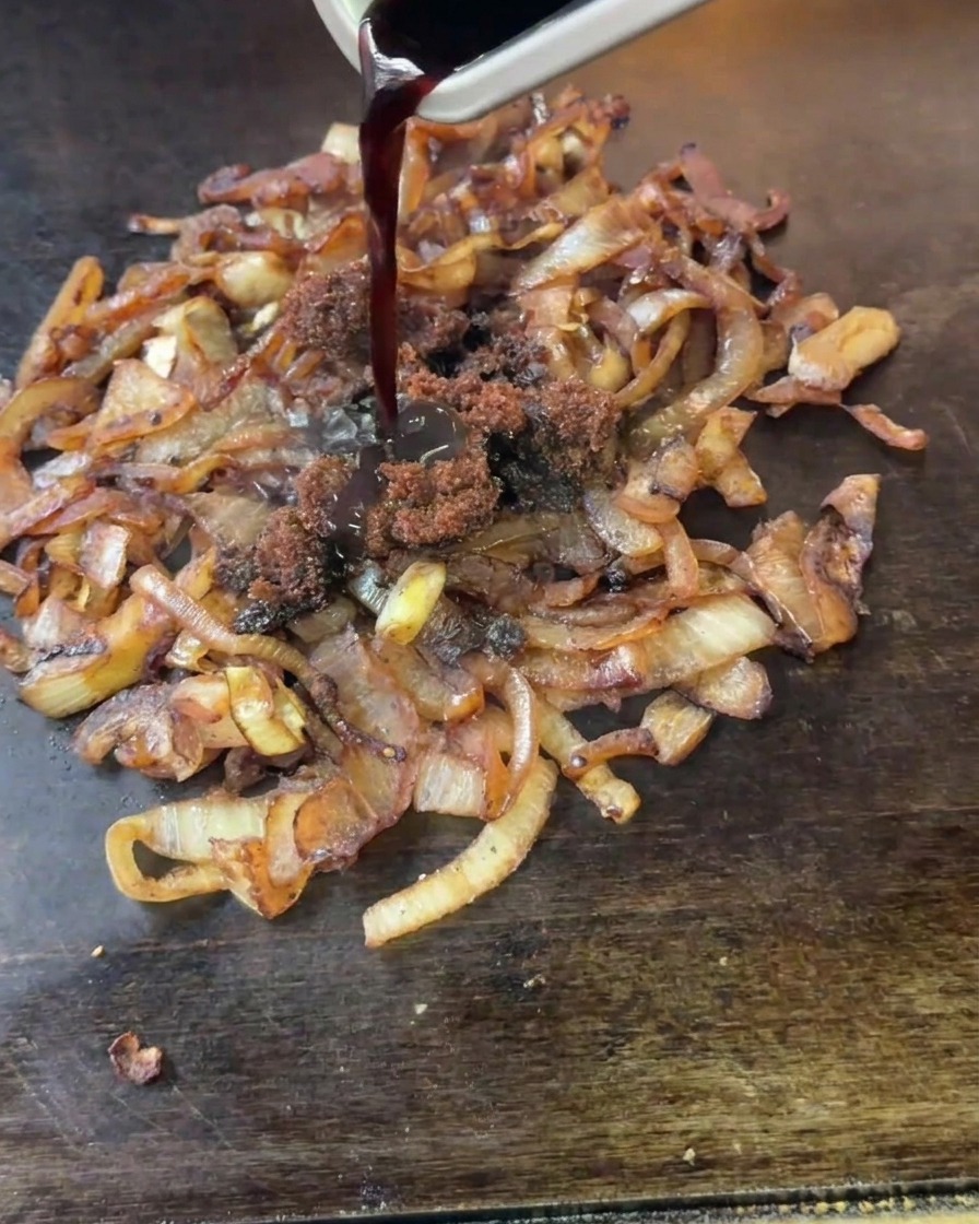볶고 있는 양파 위에 황설탕과 발효 식초를 넣는 모습.