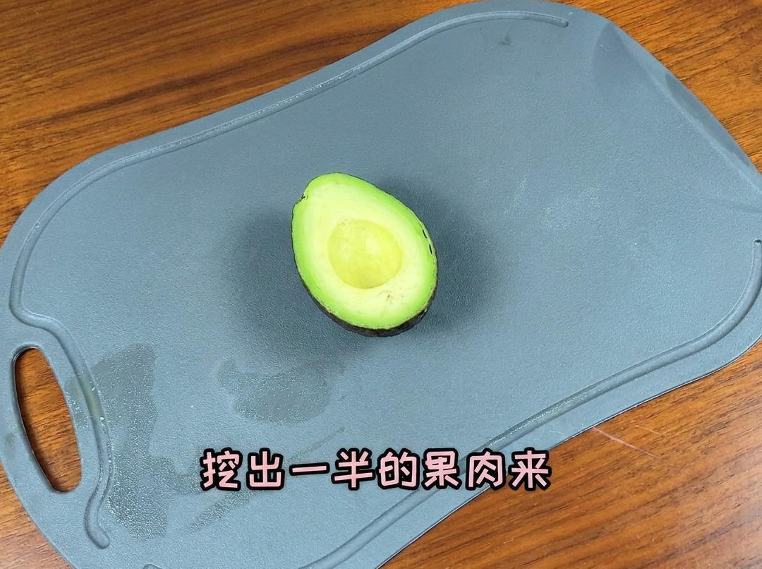 도마 위에서 반으로 갈라 씨를 제거한 아보카도를 얇게 써는 모습.