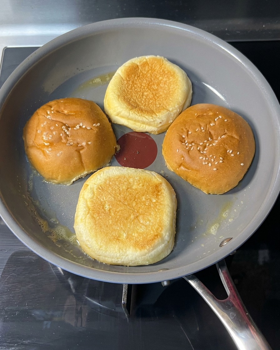 노릇하고 바삭하게 구워진 버거 번을 뒤집는 모습.
