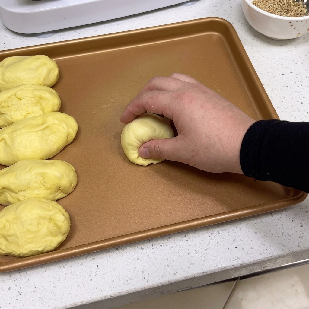 손으로 반죽을 매끄럽고 동그란 공 모양으로 빚는 모습.