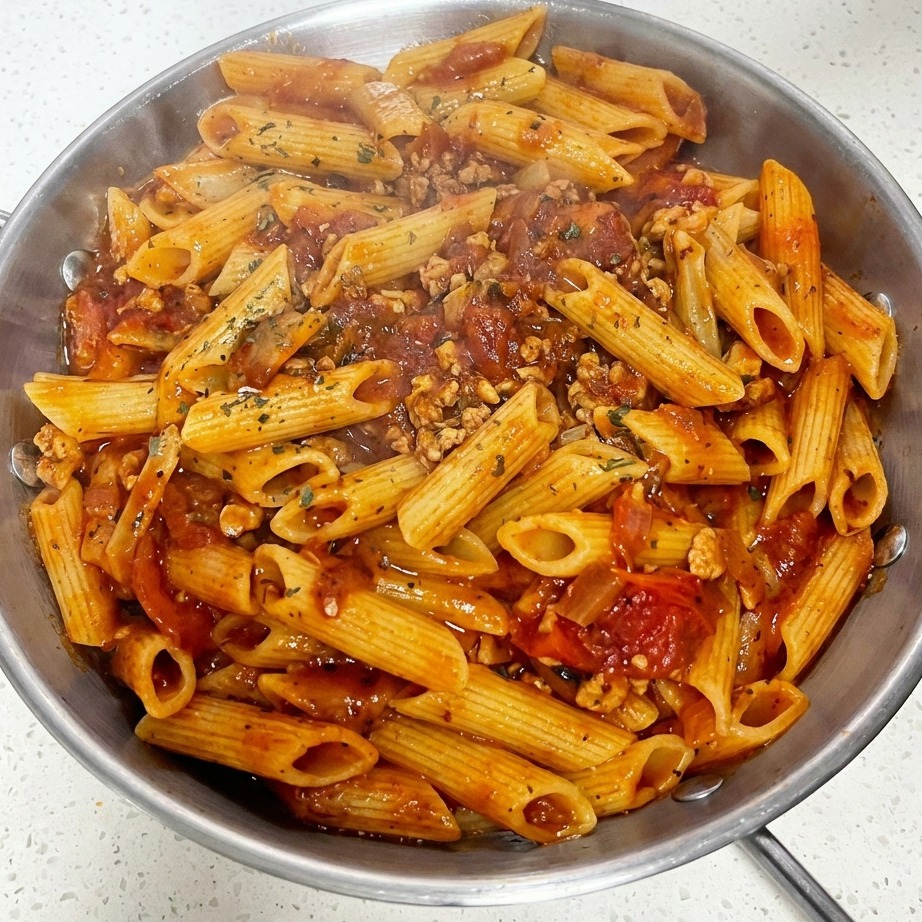 치즈가 살짝 녹은 파스타 위에 파슬리를 뿌린 완성된 요리.