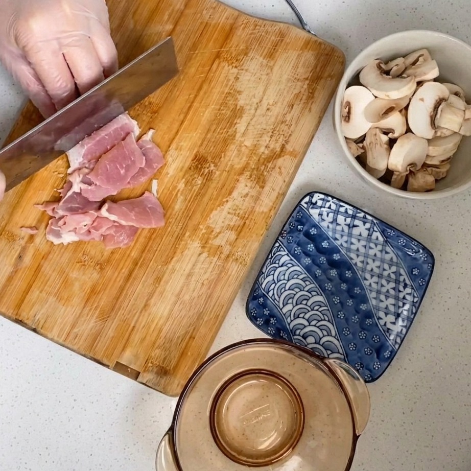 나무 도마 위에서 생돼지고기를 잘게 다지는 모습.