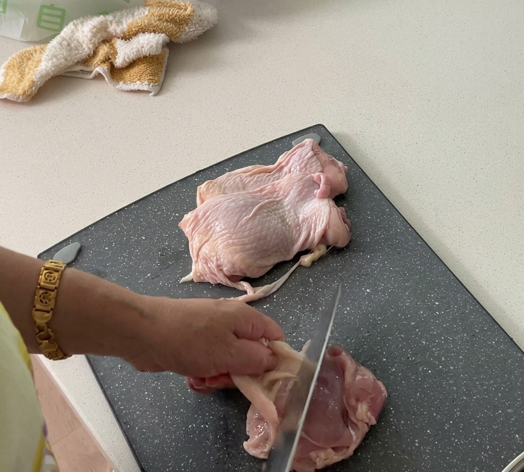 닭다리살의 껍질을 벗겨내고 살코기를 깍둑썰기하여 준비하는 모습.