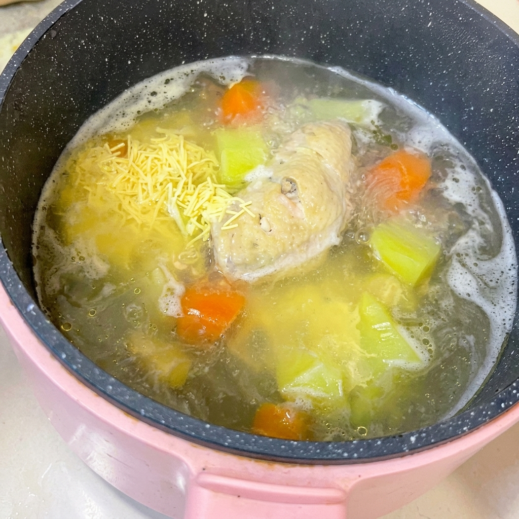 도마 위에 올려진 익힌 닭날개를 칼로 뼈와 살을 분리하는 모습.