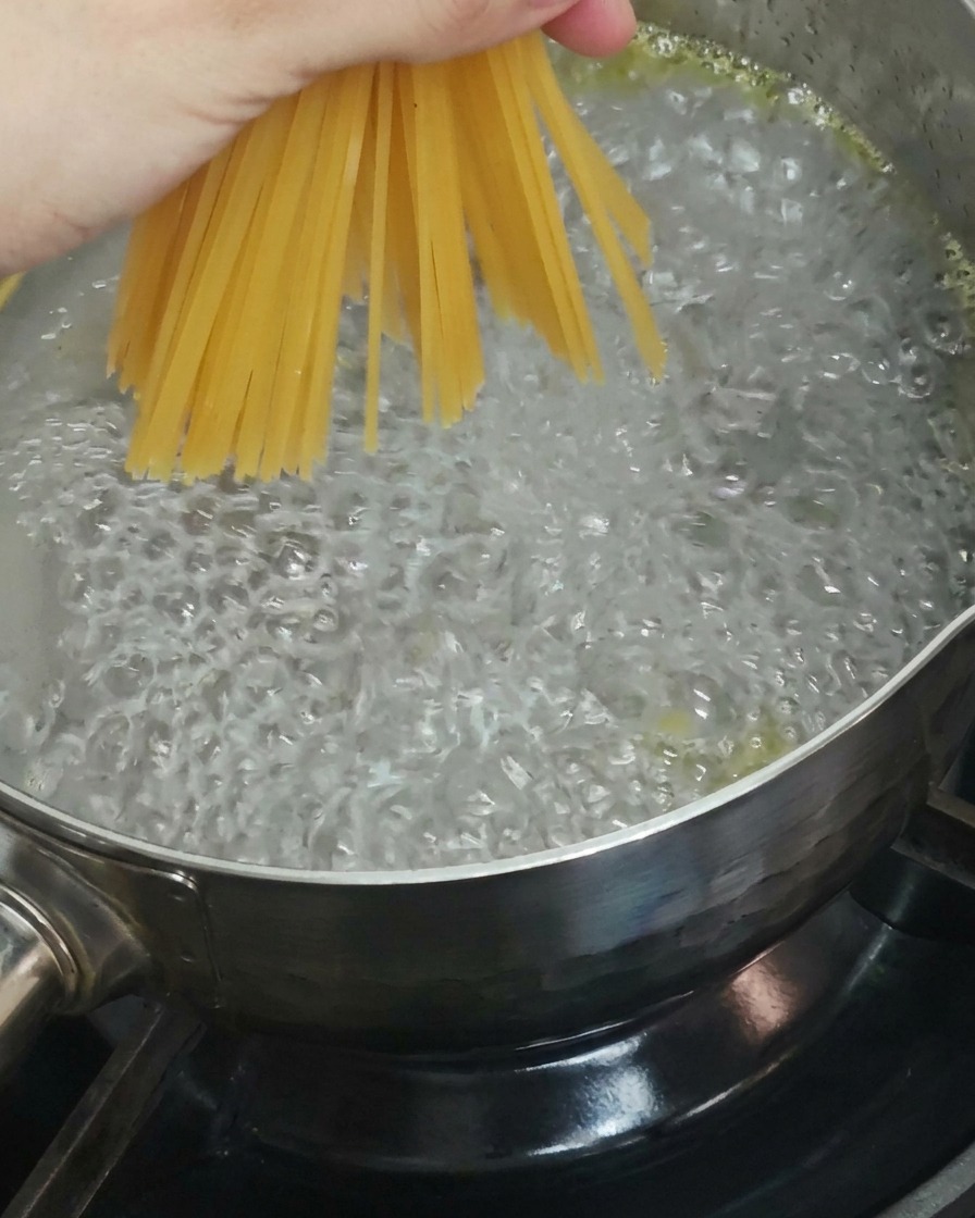 끓는 물에 스파게티 면을 넣는 모습.