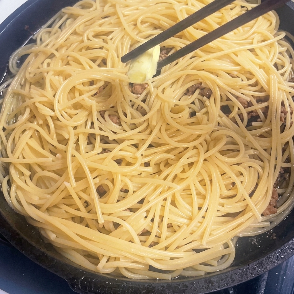 뜨거운 파스타와 고기 위에 버터 조각이 녹는 모습.