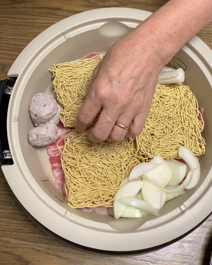 냄비 안의 재료들 사이로 떡과 유부를 넣는 모습.