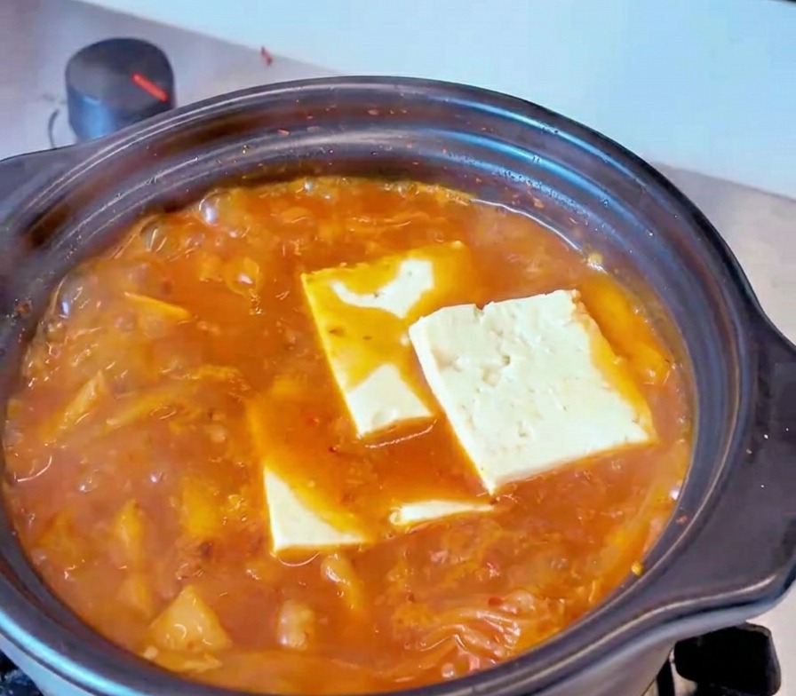보글보글 끓고 있는 붉은 김치찌개 국물에 직사각형 모양으로 썬 하얀 두부를 넣은 모습
